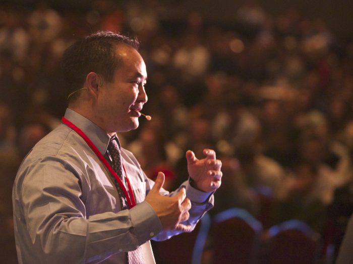 Dennis Yu speaking on stage